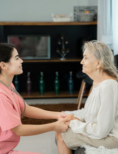 Senior care assistant with cheerful disabled woman in nursing home,Psychological support concept.