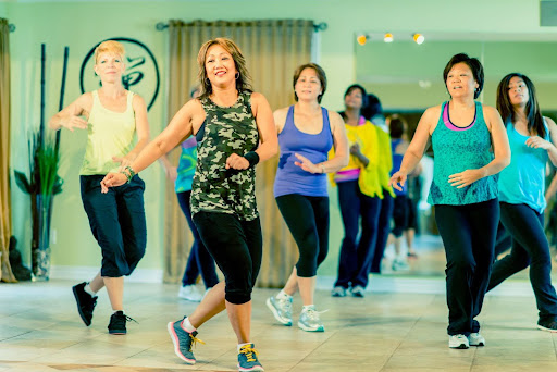 A group of seniors dances together in a bright studio, showcasing how Zumba helps older adults stay active through fun and engaging movement routines.
