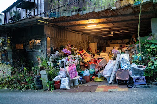 Cluttered garage overflowing with bags, boxes, and household items, illustrating the challenges of hoarding among seniors and the need for compassionate housekeeping support.