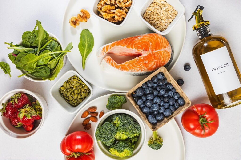 Assortment of healthy anti-inflammatory foods including salmon, olive oil, berries, nuts, and vegetables, ideal for easy senior meal prep at home.
