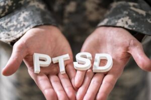 Hands of an older adult holding PTSD letters, symbolizing trauma-informed personal care and support for seniors living with PTSD.