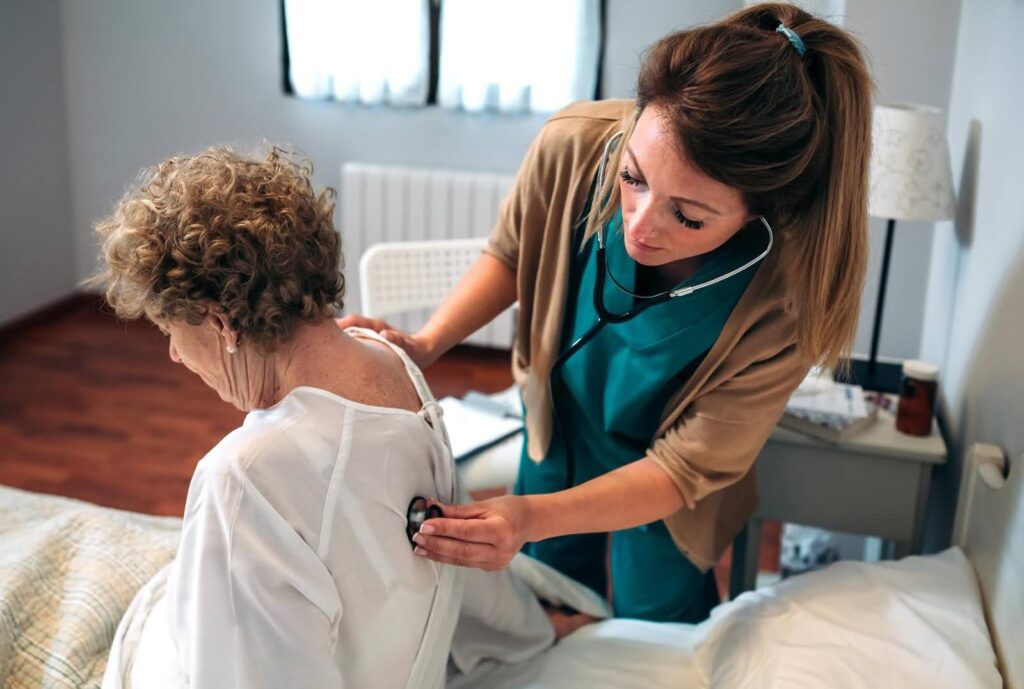 Nurse checking the health of an elderly woman at home, highlighting how undernutrition among seniors can go unnoticed without proper care.