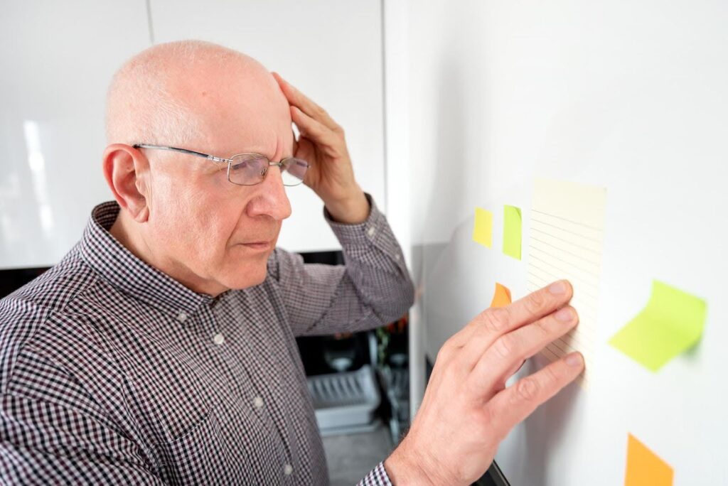 Ace Home Care support for seniors experiencing cognitive decline, showing an older adult concentrating on memory notes at home and exploring how home care may help slow mental decline.