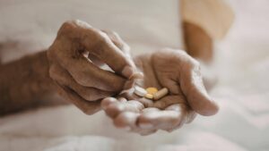 Ace Home Care supporting seniors with polypharmacy through safe medication management, showing an older adult holding multiple pills to highlight the importance of proper dosing, monitoring, and coordinated home care support.