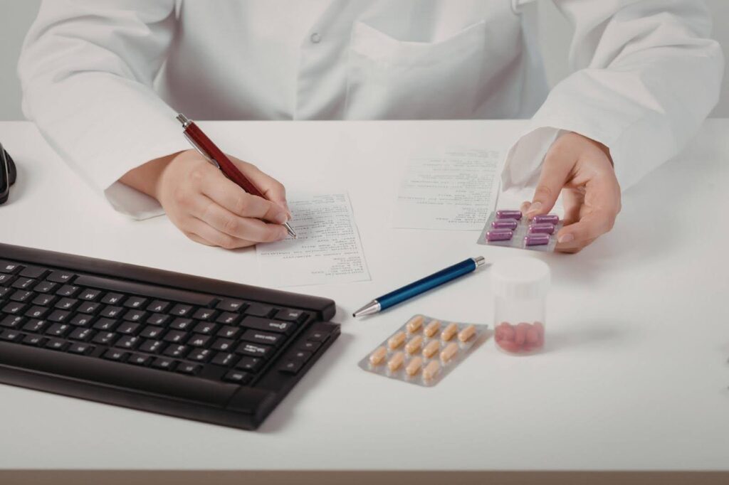 Healthcare professional reviewing prescriptions and PRN medication at a desk, highlighting the importance of daily and PRN reminders with supportive care from Ace Home Care.