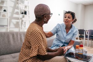 Private caregiver from Ace Home Care offering companionship and personal support to an elderly woman at home.