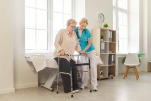 Senior receiving mobility assistance at home illustrating the difference between living alone and living safely with Ace Home Care