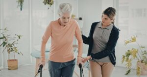 Caregiver providing concierge-level support to a senior using a walker at home with Ace Home Care