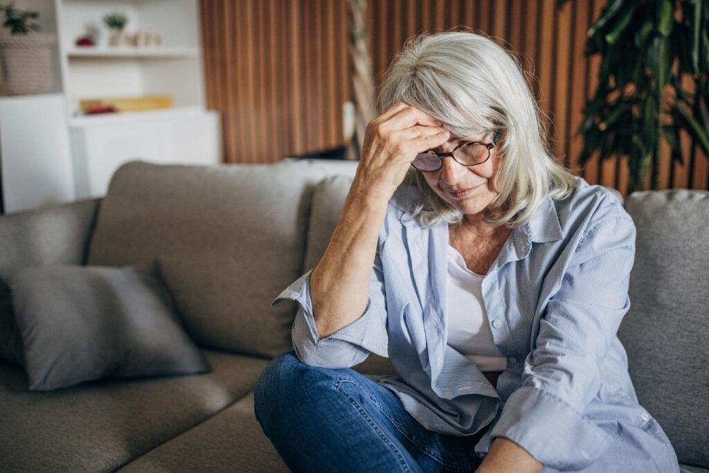 Senior woman sitting alone at home feeling isolated, highlighting how companion care from Ace Home Care can help