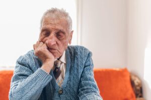 Elderly man sitting thoughtfully at home, reflecting on whether home care is only for the sick with support from Ace Home Care