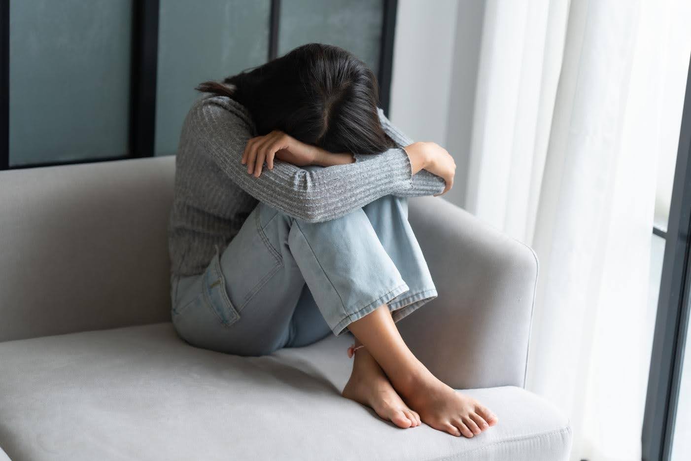 Woman sitting alone feeling overwhelmed at home highlighting the need for support from Ace Home Care