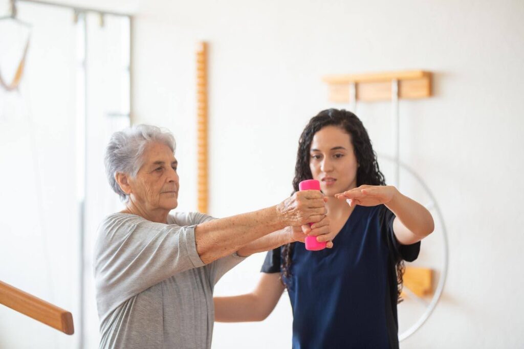 Senior working on strength exercises with caregiver support as Ace Home Care discusses the slow loss of physical independence with aging