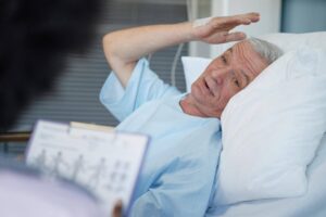 Senior recovering from illness in bed while receiving support and monitoring, highlighting how recovery from illness can take longer with age