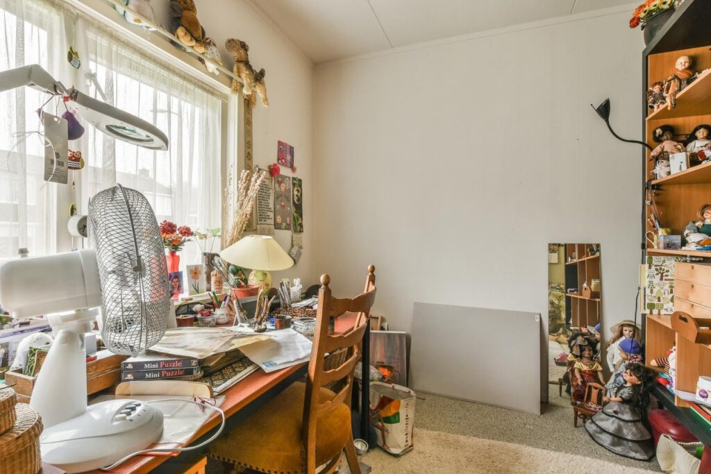 Cluttered room in a senior’s home with stacks of papers and personal belongings, illustrating how household changes may reveal important clues about a parent's health and well-being, as discussed by Ace Home Care