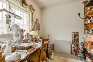 Cluttered room in a senior’s home with stacks of papers and personal belongings, illustrating how household changes may reveal important clues about a parent's health and well-being, as discussed by Ace Home Care