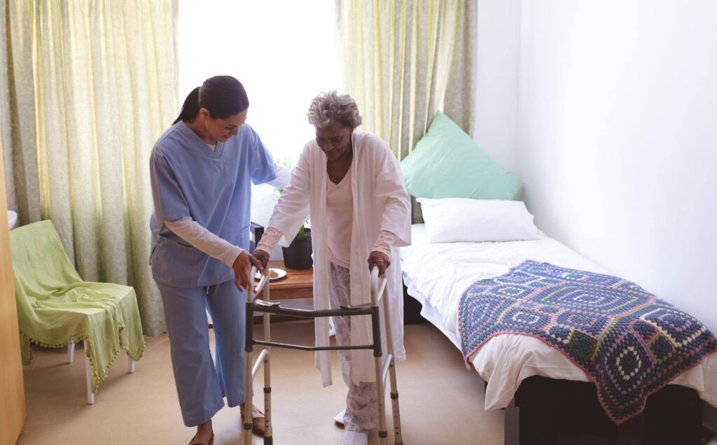Ace Home Care caregiver assisting a senior with mobility support at home, highlighting the difference between home care and nursing home care for aging loved ones