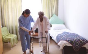 Ace Home Care caregiver assisting a senior with mobility support at home, highlighting the difference between home care and nursing home care for aging loved ones