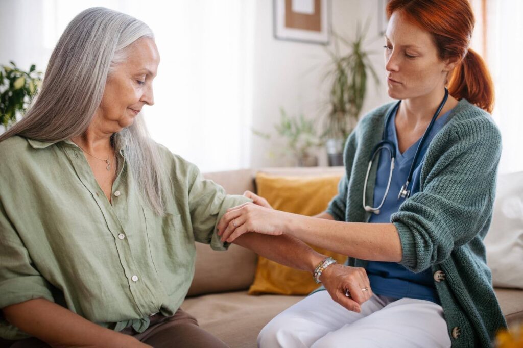 Caregiver assisting an older adult with senior health needs at home, showing how common health conditions can affect daily activities and independence with support from Ace Home Care.