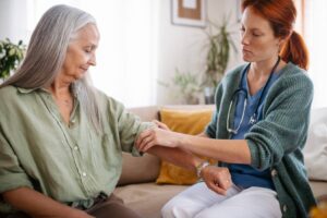 Caregiver assisting an older adult with senior health needs at home, showing how common health conditions can affect daily activities and independence with support from Ace Home Care.