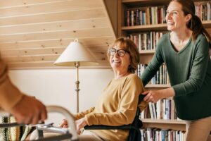 Caregiver supporting an aging parent with mobility at home, helping her stay engaged, comfortable, and connected with others through Ace Home Care.