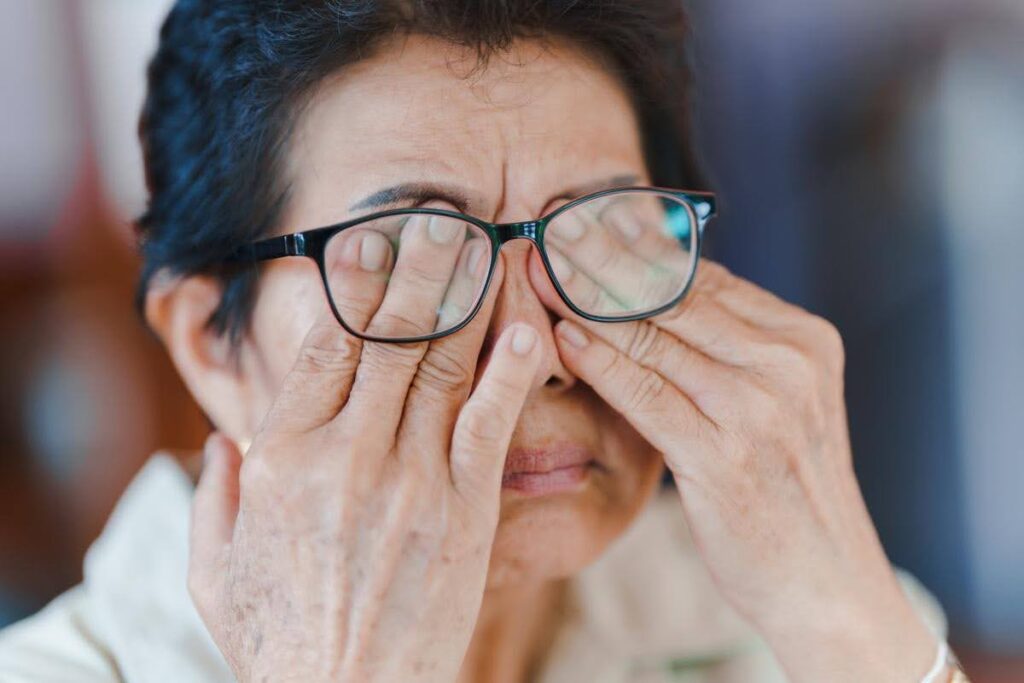 Older adult experiencing vision changes and eye discomfort, highlighting household safety risks for seniors and the supportive care available from Ace Home Care.