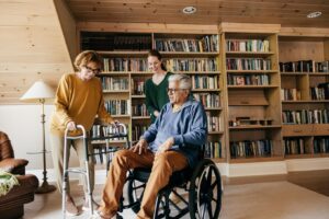 Aging parent using a wheelchair at home with family support, showing when additional help from Ace Home Care may be needed.