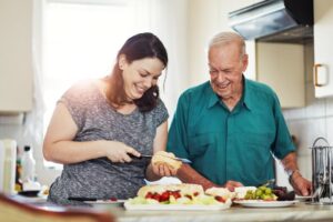 Aging parent preparing a meal at home with family assistance, showing when additional support from Ace Home Care may help maintain independence.