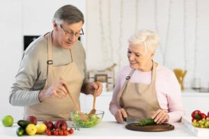 Senior couple preparing a healthy meal together at home, highlighting meal preparation challenges seniors with Parkinson’s may experience and support from Ace Home Care.