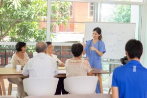 Caregiver leading an educational session for older adults, highlighting community engagement, senior care needs, and the importance of understanding local competition before opening a home care franchise.