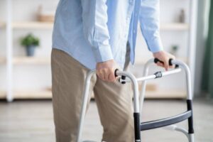 An aging parent using a walker for mobility support at home, highlighting the importance of flexible caregiving assistance for unexpected daily needs.